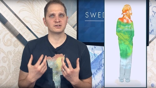 7.07 - Swedenborg Foundation Curtis at the anchor desk, an illustration to his left of a human form, filled with grey, green and orange, corresponding to the earthly, spiritual, and heavenly levels.